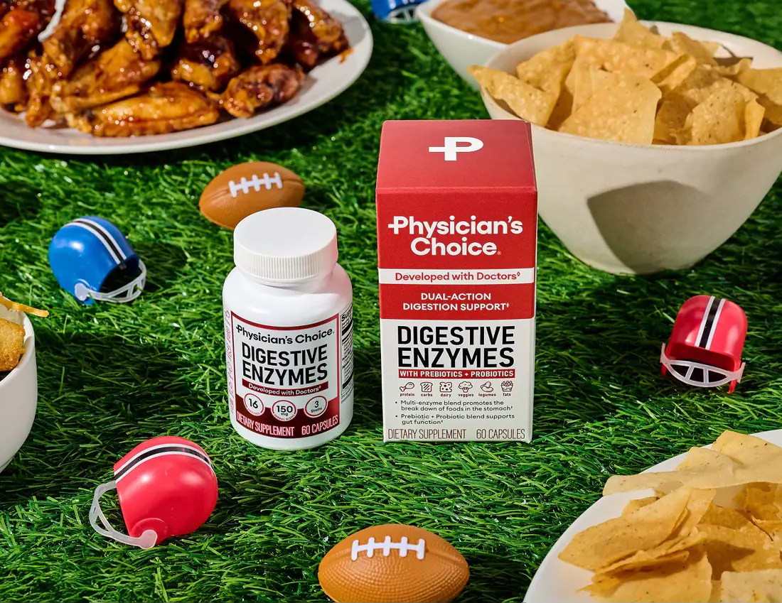 Physician's Choice Digestive Enzymes box and bottle on a game-day snack spread with wings, chips, and mini football helmets