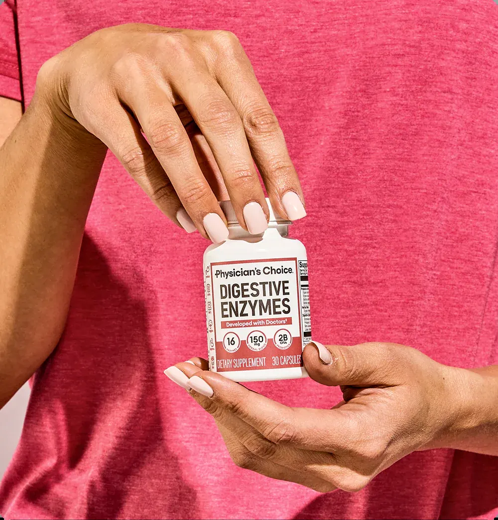 Woman in a pink shirt opening a bottle of Digestive Enzymes