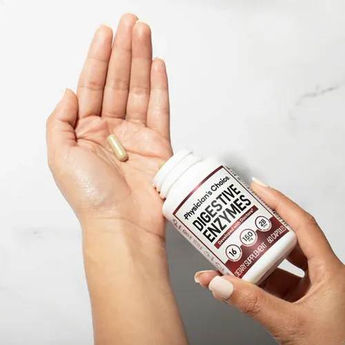 Hand holding a Digestive Enzymes capsule next to the bottle